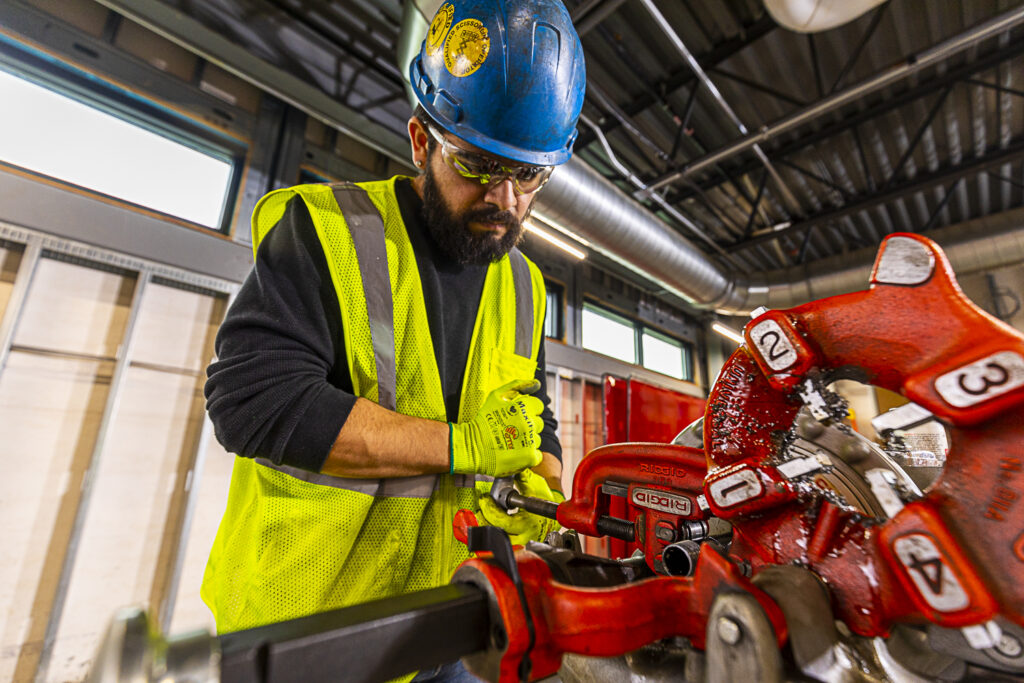 a steamfitter tighting up some pipes