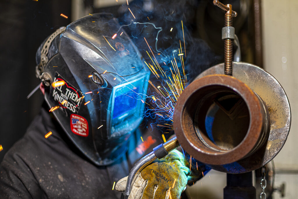 A steamfitter welding a piece of pipe